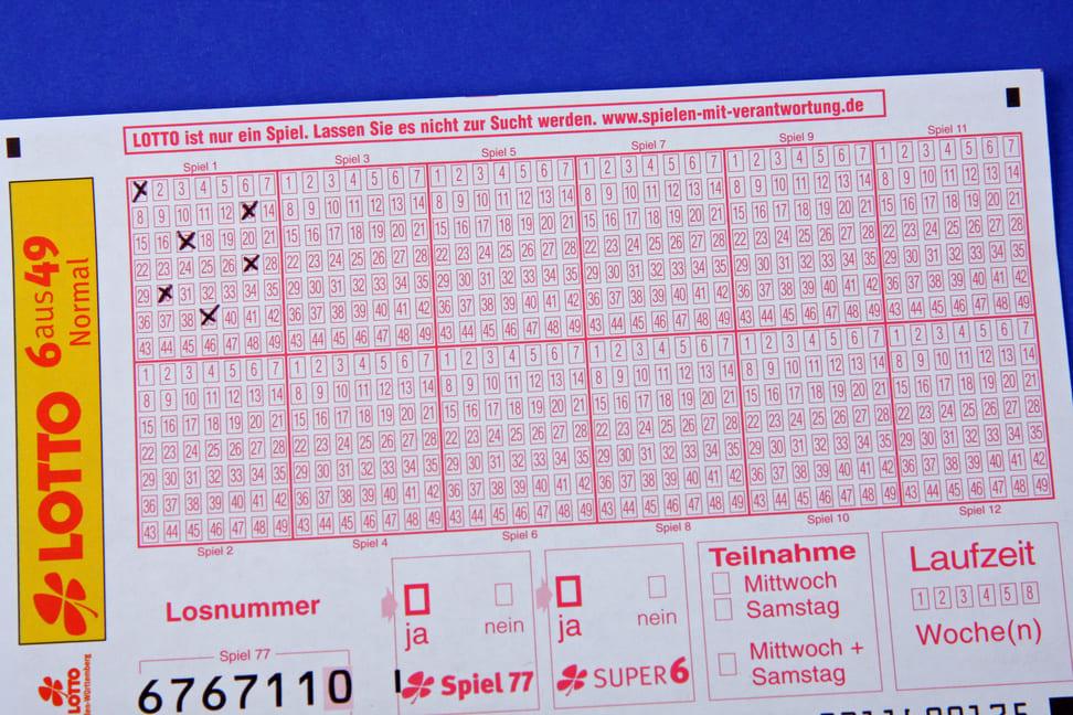 Nahaufnahme eines ausgefüllten Lotto 6 aus 49 Scheins mit mehreren markierten Zahlen. Oben ist eine Warnung zu sehen, die auf die Gefahren der Spielsucht hinweist und auf verantwortungsvolles Spielen aufmerksam macht. Perfekte Darstellung für den Einstieg ins Eurojackpot online spielen.