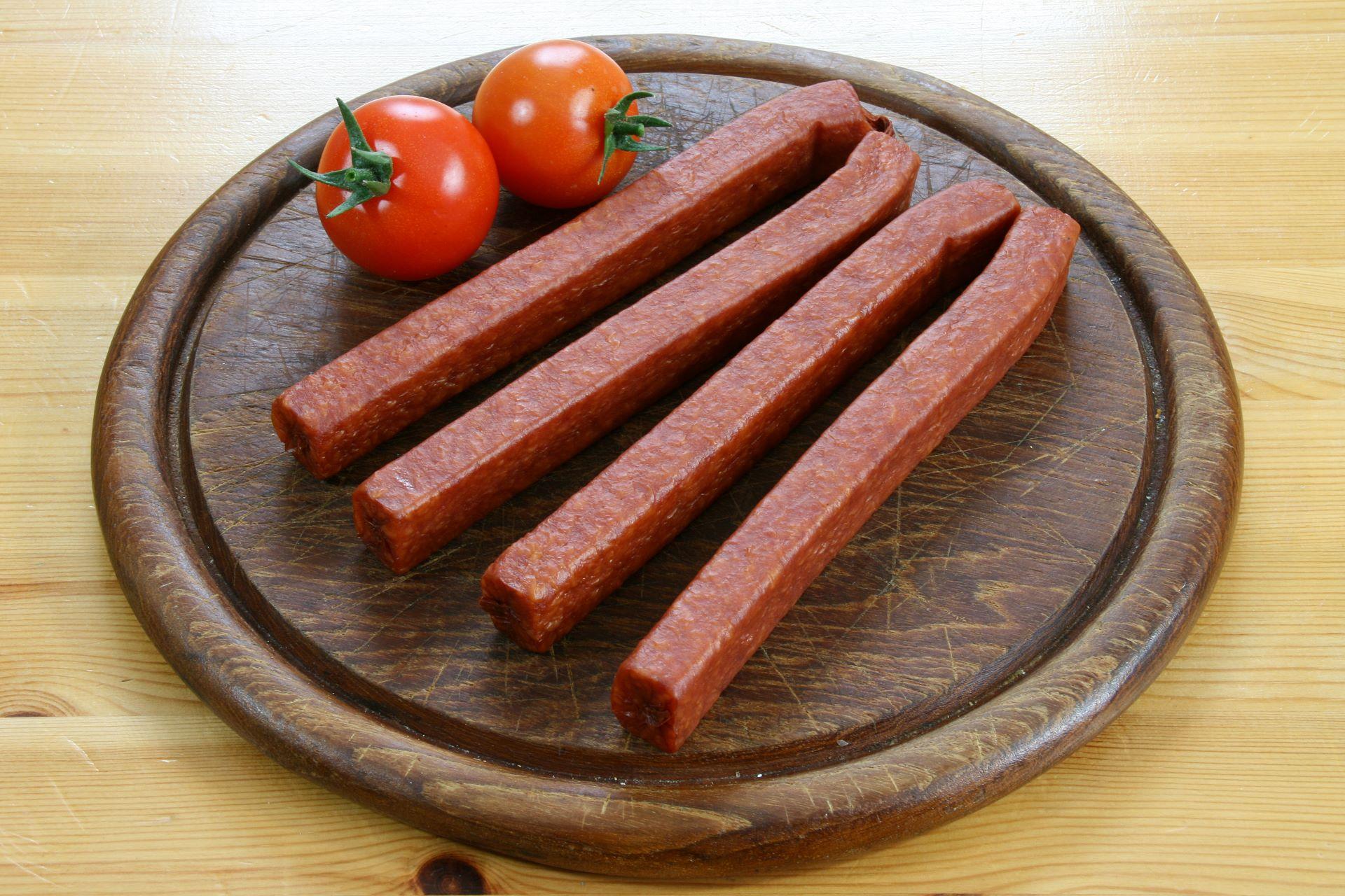 Landjäger-Würste auf Holzbrett mit Tomaten