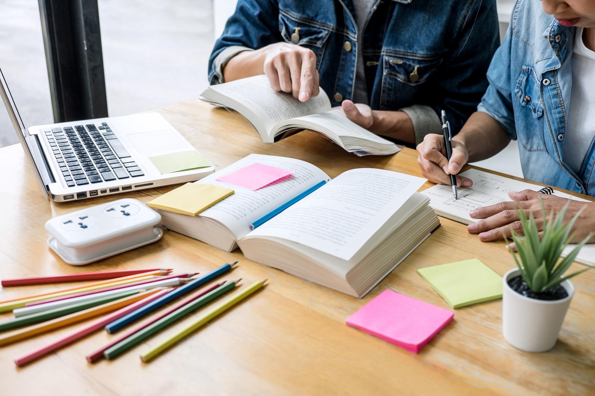 Zwei Personen lernen mit Laptop und Büchern | E-Learning Anbieter